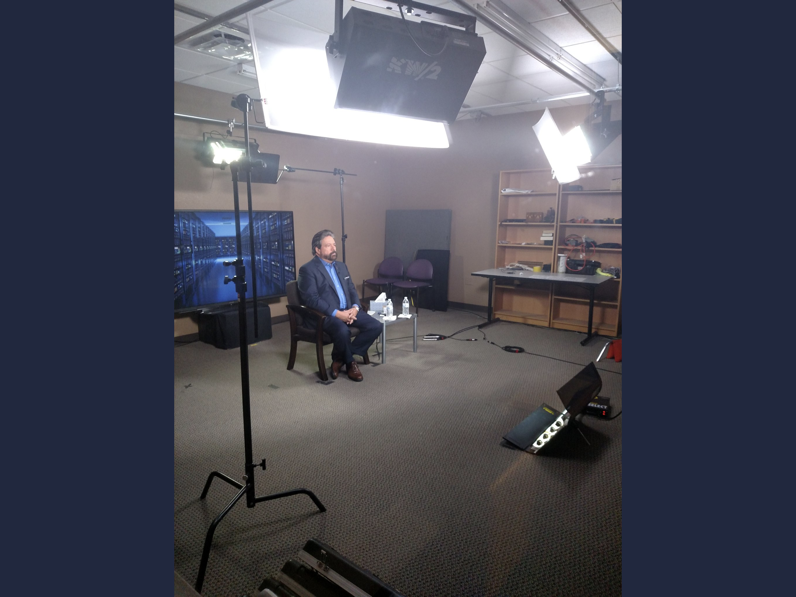 Television studio interview setup with news backdrop