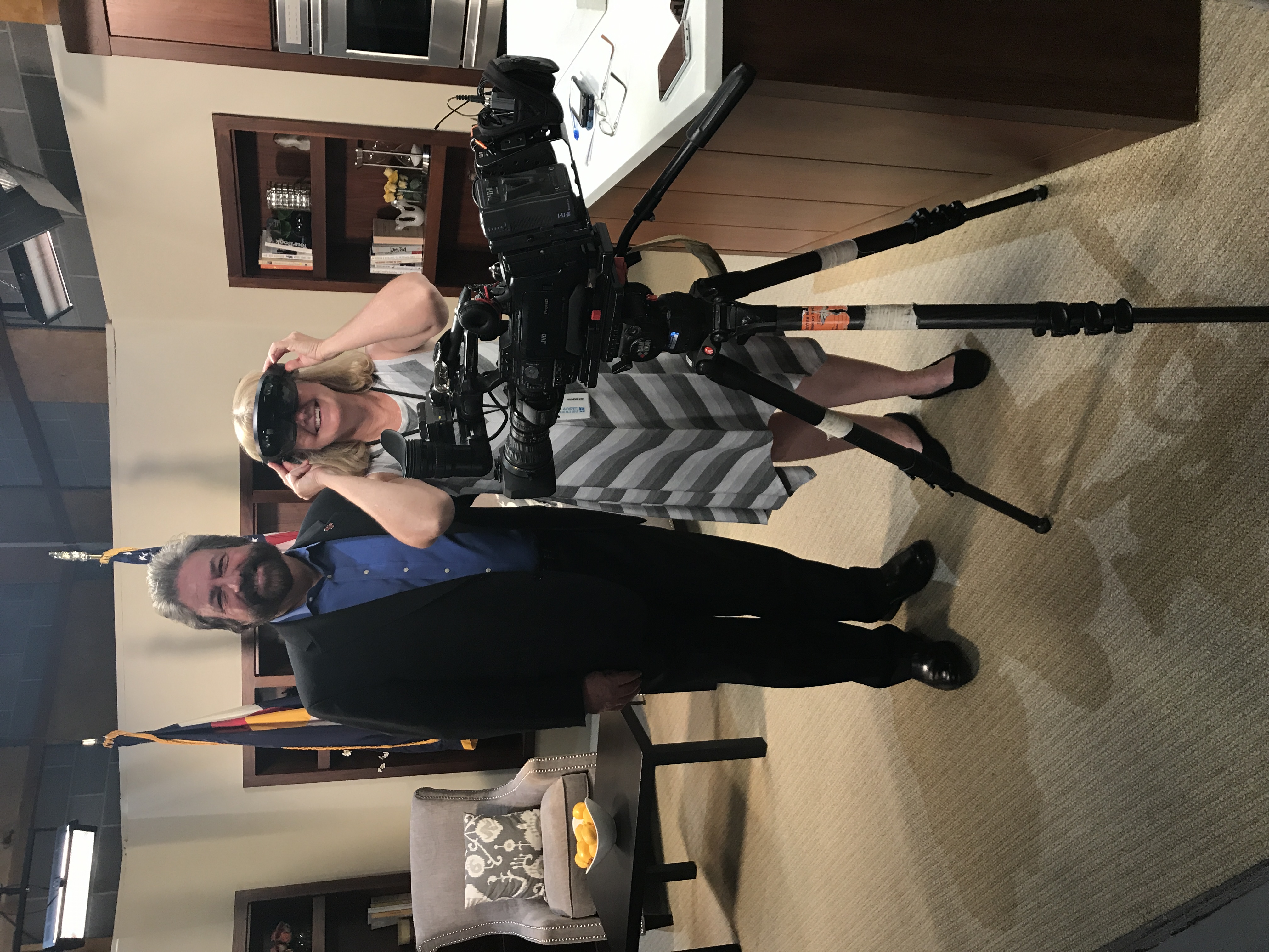 Dennis Bonilla with a producer trying on an AR headset on a TV studio set