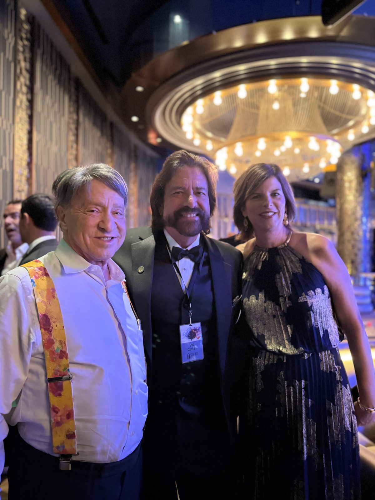 Dennis Bonilla with colleagues under a grand chandelier at the Aoki Gala