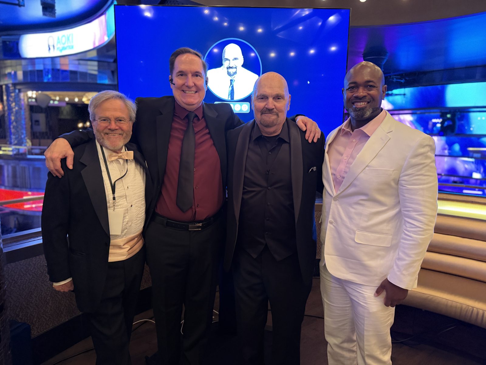 Dennis Bonilla with colleagues in front of an AOKI screen backdrop