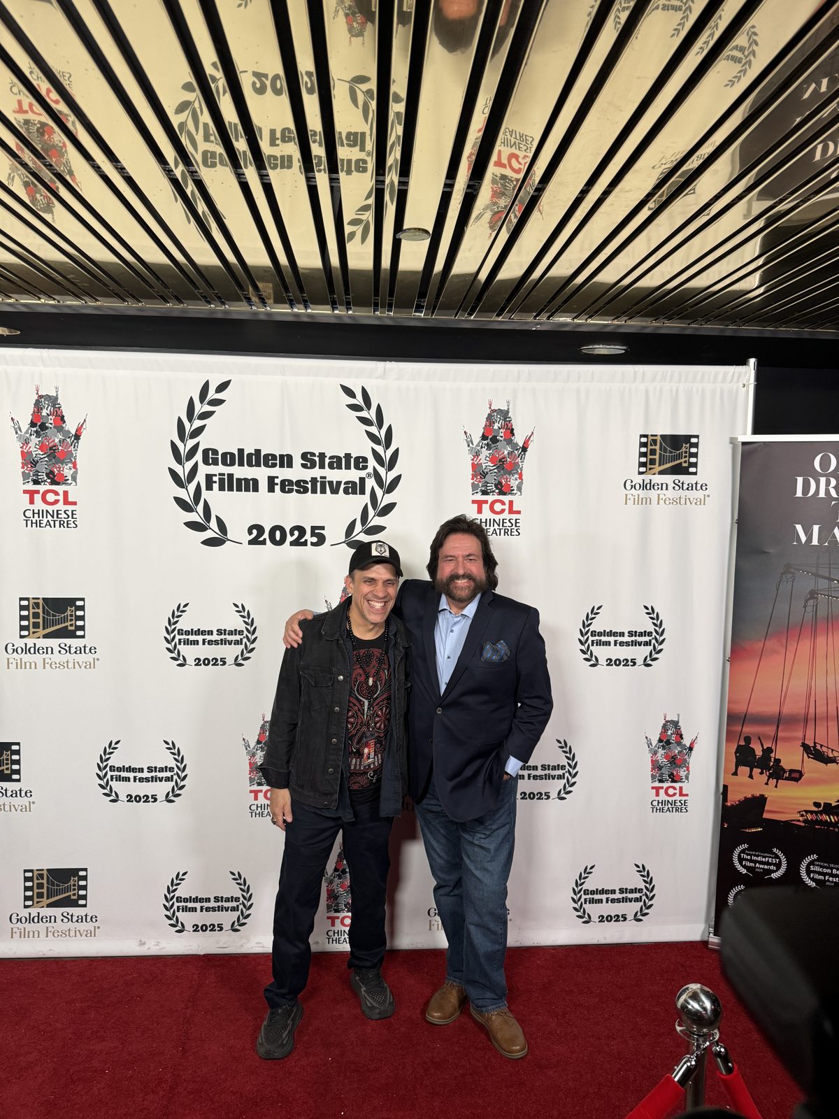 Dennis Bonilla with a filmmaker on the red carpet at the 2025 Golden State Film Festival